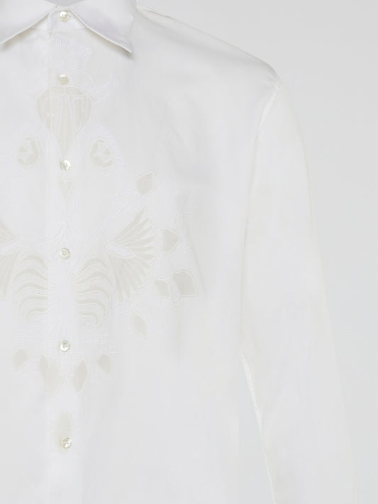 Step into a realm of elegance with the White Embroidered Shirt by Roberto Cavalli, where classic sophistication meets modern charm. Crafted with meticulous attention to detail, this shirt showcases exquisite floral embroidery that dances gracefully across the pristine white fabric. Embrace your inner fashion icon as you effortlessly blend timeless style with a touch of Italian flair, making a statement that is as timeless as it is enchanting.