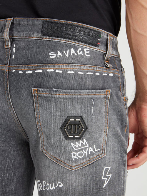 Серые джинсы с рисунками и заплатками