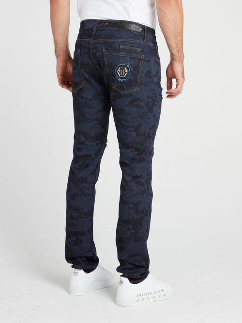 Темно-синие джинсы с камуфляжным принтом и рваной отделкой