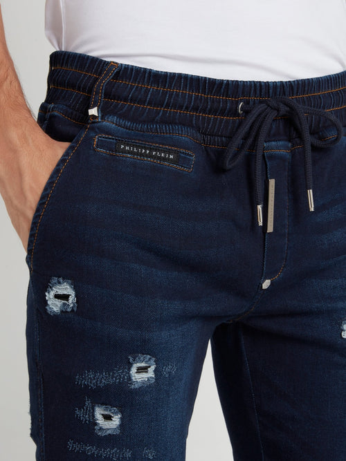 Темно-синие брюки с рваной отделкой